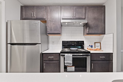 a kitchen with gray cabinets and stainless steel appliances